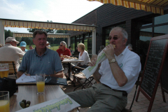 Rick Jones looks on as Mike Houghton enjoys a French delicacy.